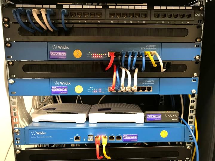 Cat 6 patch panel and PoE modules above a phone system