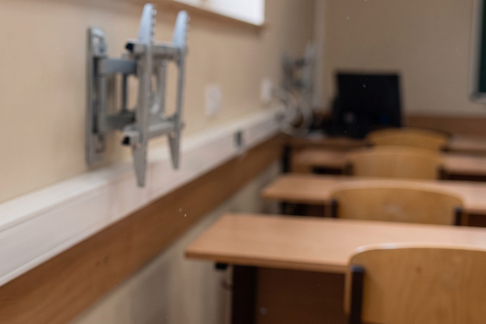 Goulotte de c&acirc;blage et support mural d'&eacute;cran install&eacute;s le long du mur d'une salle de classe vide