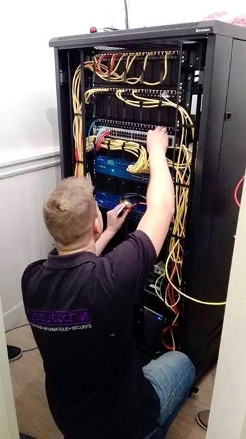 Technicien Assutech raccordant une baie de brassage chez un client