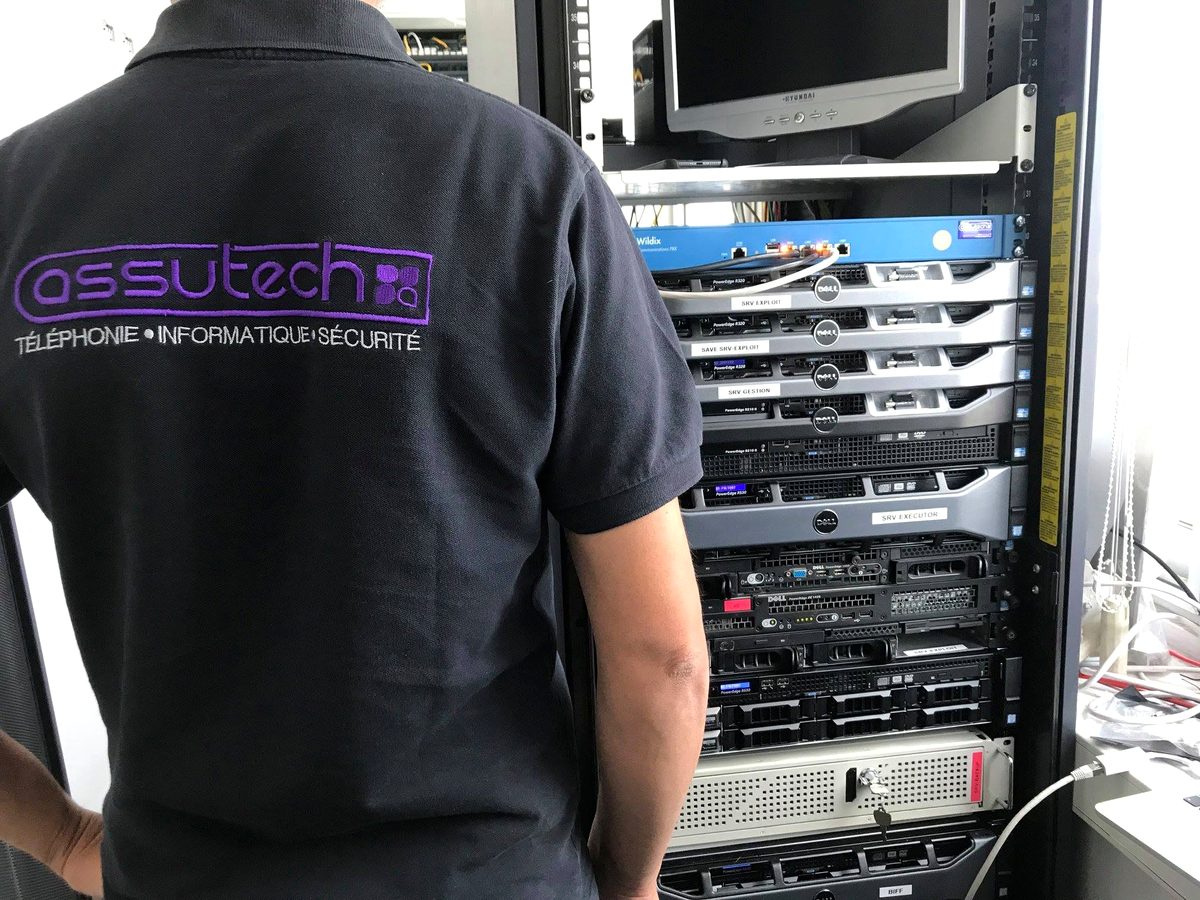 Technicien Assutech en intervention devant une baie serveurs